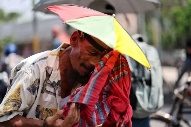 عامل يمسح عرقه خلال موجة حر في بنغلاديش (رويترز)