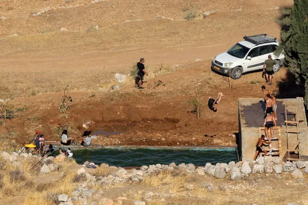 مستوطنون يسبحون في آبار «عين سامية» بالضفة 15 يوليو 2025 (أ.ف.ب)