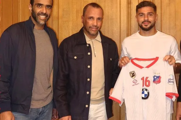 مرسي حاملاً قميص الكويت إلى جانب أعضاء النادي (الشرق الأوسط)