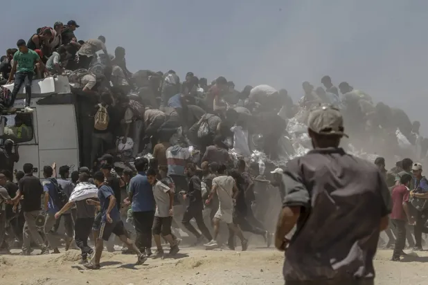 Filistinliler, dün Gazze Şeridi'nin kuzeyinde Zikim'deki dağıtım noktası yakınında bir yardım kamyonundan un torbaları almak için çabalıyor (EPA)