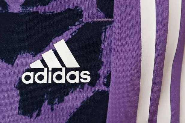 The logo of the German sports equipment maker Adidas is pictured prior to the company's annual press conference in Herzogenaurach, southern Germany on March 8, 2023. (AFP)