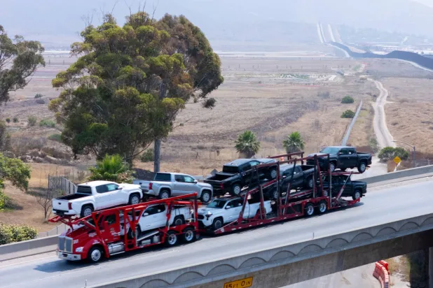 شاحنات «تويوتا» مصنَّعة في تيخوانا بالمكسيك تُنقل عبر جسر إلى الولايات المتحدة (رويترز)