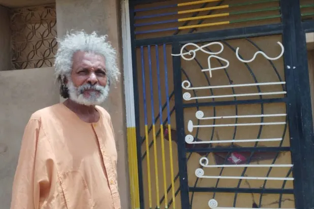 الفنان أبو عركي أمام داره التي لم يغادرها طوال أيام الحرب في العاصمة الخرطوم (الشرق الأوسط)