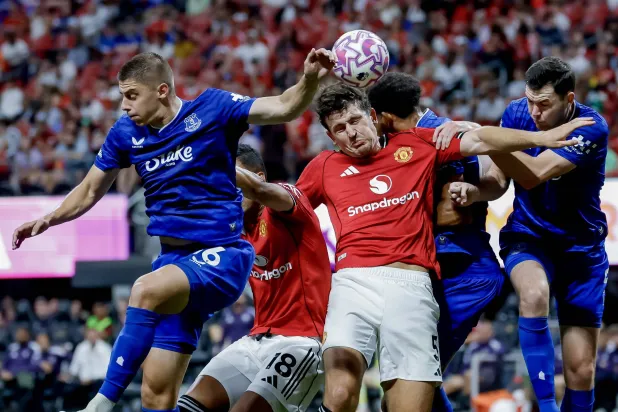 هاري ماغواير من مانشستر يونايتد في مواجهة فيتالي ميكولينكو وجيمس تاركوفسكي من إيفرتون خلال مباراة ودية ضمن سلسلة الدوري الإنجليزي الممتاز الصيفية في أتلانتا (إ.ب.أ)