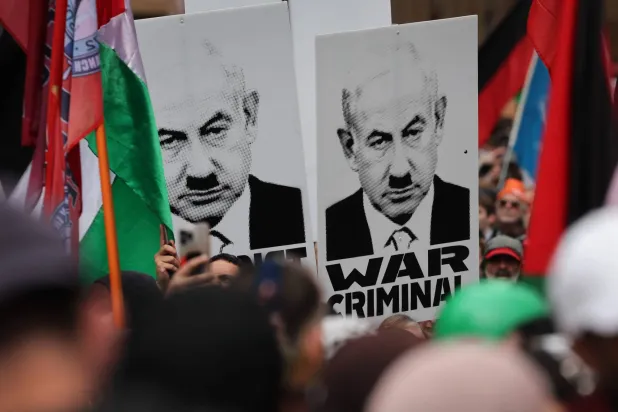 متظاهرون يحملون لافتات تصوّر رئيس الوزراء الإسرائيلي بنيامين نتنياهو بصورة هتلر خلال مظاهرة مؤيدة للفلسطينيين ضد تصرفات إسرائيل ونقص الغذاء المستمر بقطاع غزة في سيدني (أ.ف.ب)