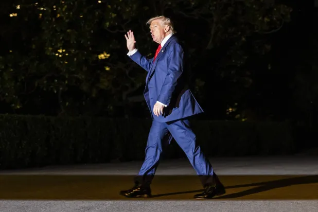 الرئيس الأميركي يلوح بيده لدى عودته إلى البيت الأبيض بعد عطلة نهاية أسبوع في بيدمينستر (إ.ب.أ)