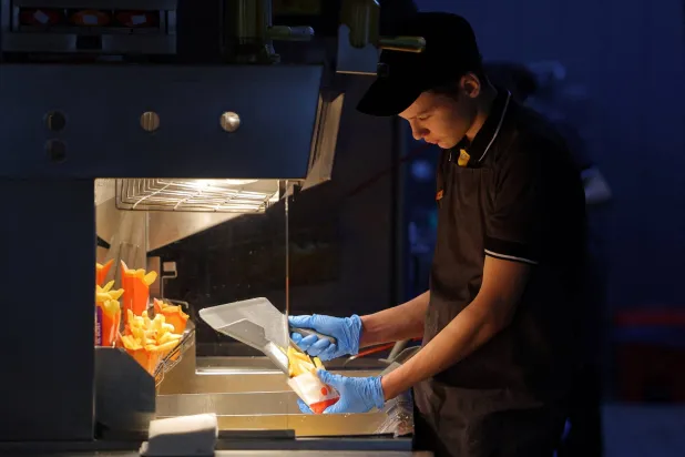 موظف يطهو بطاطس مقلية في مطعم «فكوسنو إي توتشكا» بموسكو (أرشيفية - رويترز)
