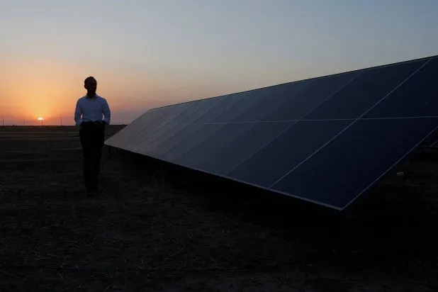 A man walks near solar panels on his farm, an increasingly popular sustainable energy option for homes and farms to generate electricity, in Mosul, Iraq, July 8, 2025. (Reuters) 