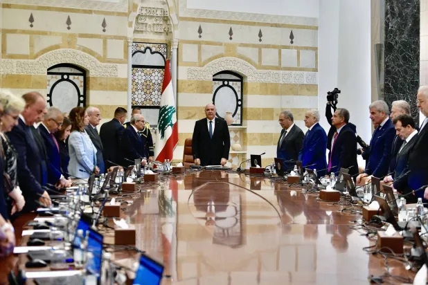 الرئيس اللبناني جوزيف عون وأعضاء الحكومة وقوفاً قبيل بدء الجلسة (إ.ب.أ)