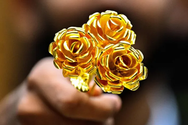 قطعة ذهبية على شكل وردة عيار 24 قيراطاً تزن أونصة واحدة معروضة للبيع في سوق الذهب المركزية في الكويت (أ.ف.ب)