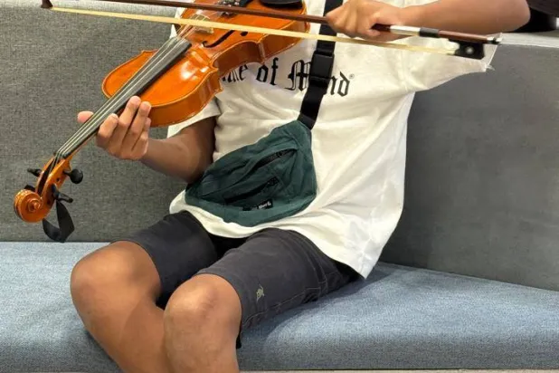 متدرب يجرب العزف على آلة الكمان (الشرق الأوسط)