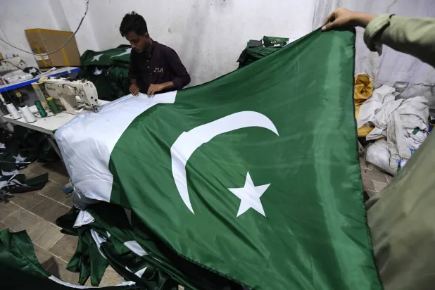 حِرفيٌ يخيط الأعلام الوطنية بمصنع قبل احتفالات «يوم الاستقلال» الباكستاني... في كراتشي بباكستان يوم 6 أغسطس 2025... ويُحتفل بهذا اليوم سنوياً في 14 أغسطس لإحياء ذكرى نهاية الحكم الاستعماري البريطاني عام 1947 (إ.ب.أ)