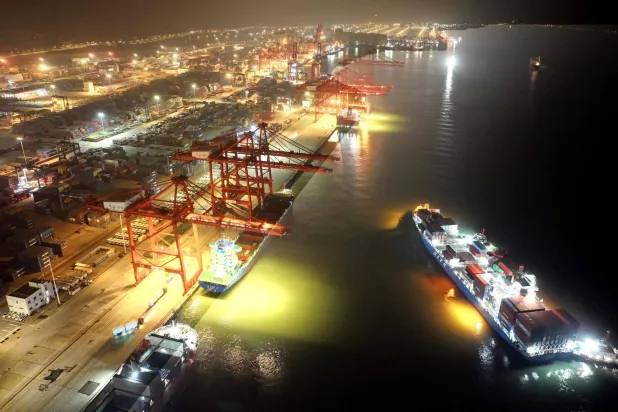 سفينة شحن في طريقها للرسوّ بميناء «ليانينغانغ» شرق الصين (أ.ف.ب)