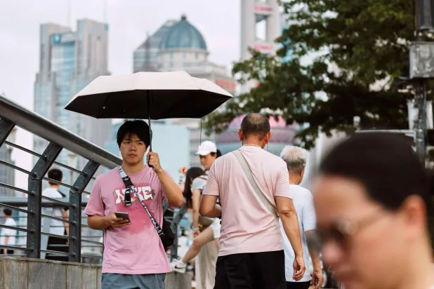 مشاة في أحد شوارع مدينة شنغهاي الصينية (إ.ب.أ)