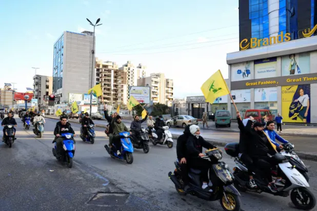 Men carry Hezbollah flags while riding on two wheelers, at the entrance of Beirut's southern suburbs, in Lebanon, November 27, 2024. REUTERS/Thaier Al-Sudani/File Photo 