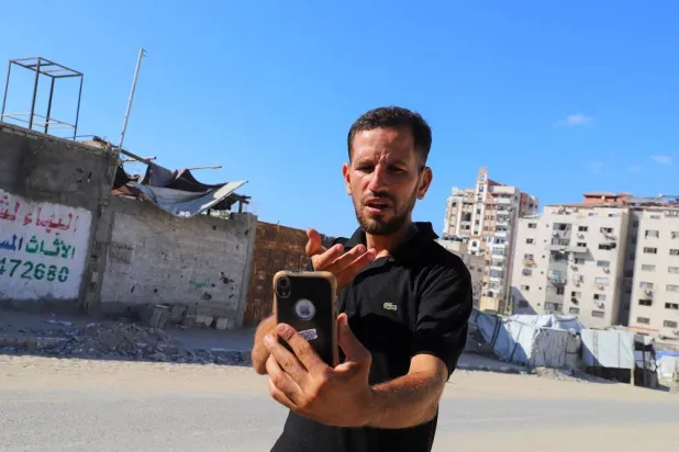 Hearing-impaired Palestinian influencer Basem Al-Habel, who turned to social media to document the war in Gaza through sign language, reaching a wide range of followers from both inside and outside of the enclave, films himself in Gaza City August 5, 2025.(Reuters)