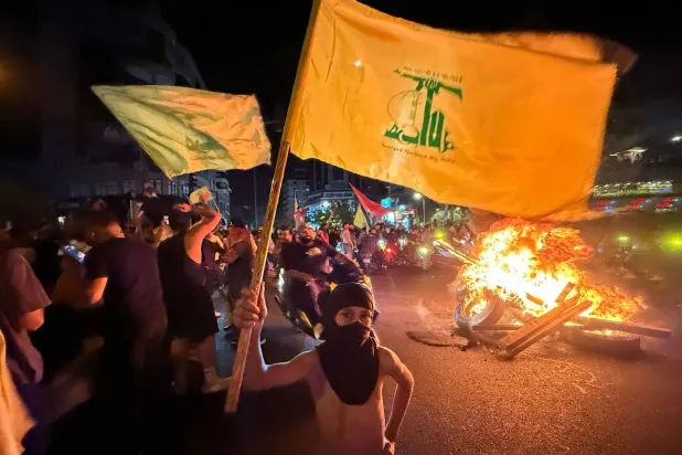 مجموعة من مناصري «حزب الله» يحرقون الإطارات مساء الخميس اعتراضاً منهم على قرار الحكومة سحب سلاح الحزب (أ.ف.ب)