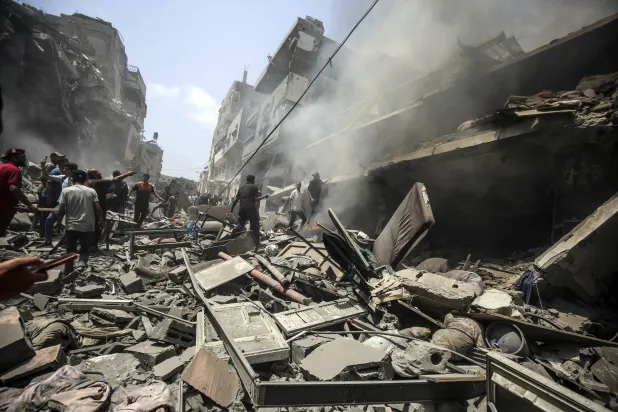 فلسطينيون يتفقدون الدمار الذي خلفته غارة إسرائيلية على حي الزيتون بجنوب مدينة غزة (د.ب.أ)