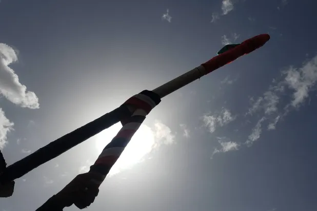 أحد أنصار الحوثيين يحمل مجسماً لطائرة مسيرة خلال احتجاج في صنعاء (إ.ب.أ)