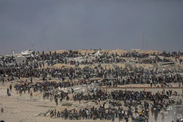 نازحون فلسطينيون ينتظرون شاحنات مساعدات قرب نقطة توزيع أغذية في زيكيم شمال قطاع غزة (إ.ب.أ)