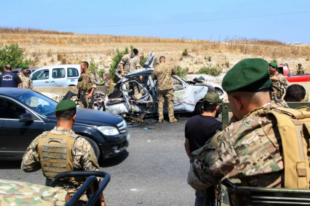 جنود لبنانيون يتفقدون حطام سيارة تعرضت لقصف إسرائيلي في جنوب مدينة صيدا الساحلية (أ.ف.ب)