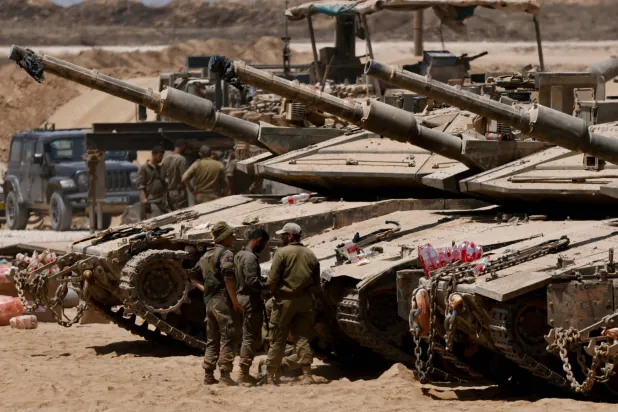 دبابات وجنود في موقع عسكري إسرائيلي قرب حدود غزة الثلاثاء الماضي (رويترز)
