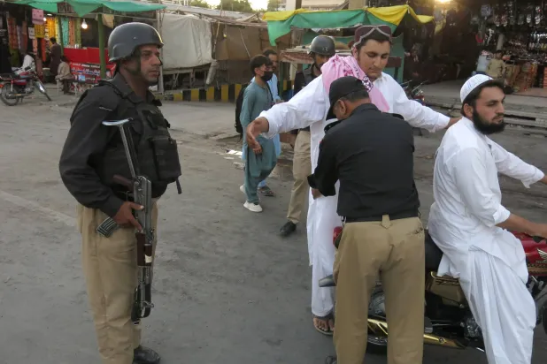 مسؤولون أمنيون باكستانيون يفتشون رجلاً عند نقطة تفتيش في كويتا عاصمة إقليم بلوشستان المضطرب... 8 أغسطس وأوقفت السلطات خدمات الإنترنت تحسباً لأي عنف محتمل خلال عيد استقلال البلاد (إ.ب.أ)