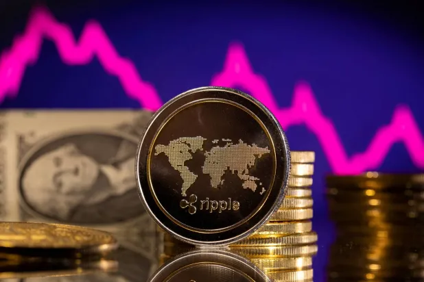 عملة مشفرة أمام رسم بياني للسهم والدولار الأميركي (رويترز)