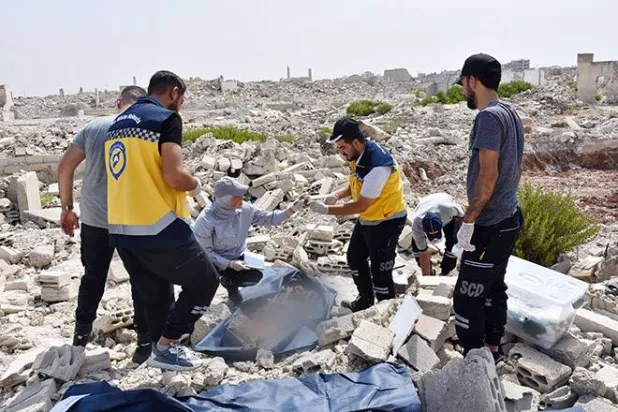 الدفاع المدني السوري عند موقع منزل مهدم ردمت تحته جثامين ضحايا مجزرة كرم الزيتون في حمص 2012 (سانا)