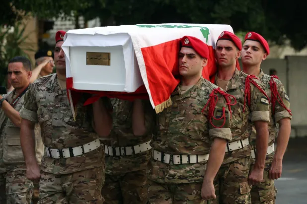 جنود لبنانيون يحملون نعش أحد رفاقهم الستة الذين قتلوا في مخزن ل"حزب الله" خلال مراسيم تشييعهم في بيروت أمس (إ.ب.أ)