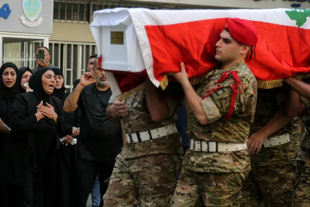 والدة جندي بالجيش اللبناني قتل بانفجار مخزن الأسلحة بالجنوب تنتحب خلال مراسم تكريم عسكرية له في أثناء تشييعه ببيروت الأحد (د.ب.أ)