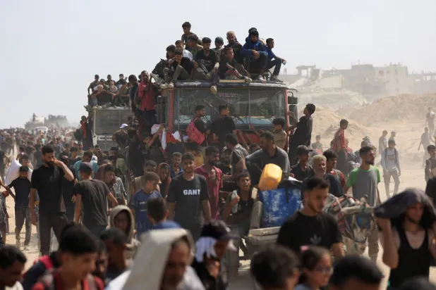 فلسطينيون يسعون للحصول على إمدادات المساعدات من الشاحنات التي دخلت شمال قطاع غزة (رويترز)