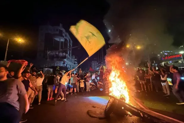 Supporters of Lebanon's Hezbollah group block the streets with burning tires as they rally in cars and motorbikes to protest the government's endorsement of a plan to disarm it, in Beirut's southern suburbs early on August 8, 2025. (AFP) 