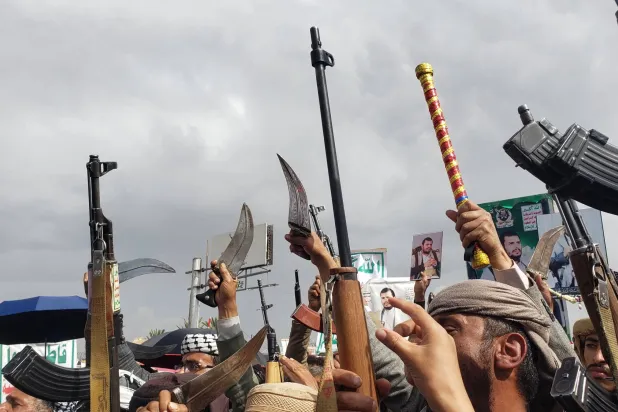 عناصر حوثيون يرفعون الأسلحة خلال حشد للجماعة في صنعاء (إ.ب.أ)