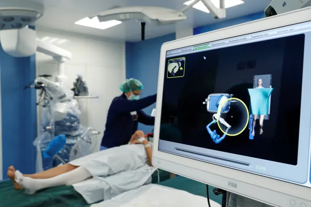 طاقم طبي يقوم بتجهيز مريضة قبل خضوعها لجراحة الركبة (رويترز)