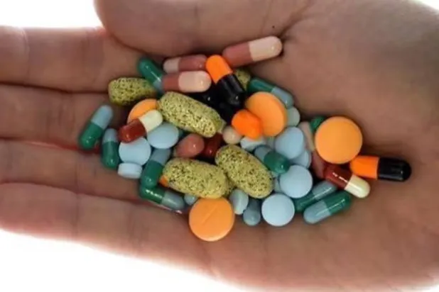 رجل يحمل بيده حبوب أدوية (رويترز)