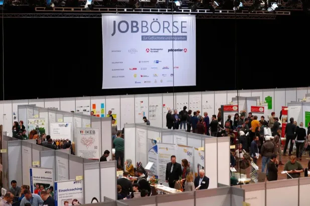 أشخاص يزورون معرض العمل الثاني للمهاجرين واللاجئين في برلين (أرشيفية - رويترز)