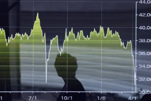 انعكاس مارة على شاشة تعرض تحركات مؤشر «نيكي» خارج شركة وساطة في طوكيو (رويترز)