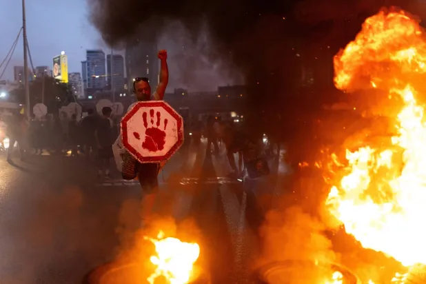 أقارب رهائن ونشطاء يسدّون طريقاً في تل أبيب للمطالبة باطلاق المحتجَزين لدى «حماس» الخميس (رويترز)