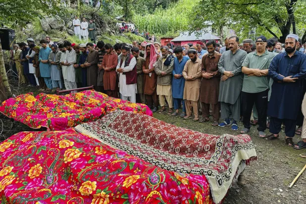 يشارك الناس في صلاة الجنازة على ضحايا حادث هطول أمطار غزيرة مفاجئة بقرية ناريان بيهاك بالقرب من مظفر آباد المدينة الرئيسية في الجزء الخاضع لسيطرة باكستان من كشمير اليوم الجمعة (أ.ب)