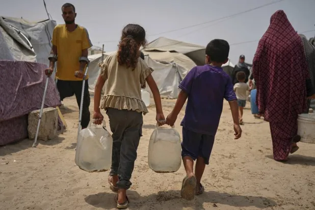  Palestinian children haul jerrycans of water collected from a distribution point in Gaza City, Aug. 12, 2025, amid scorching temperatures. (AP) 