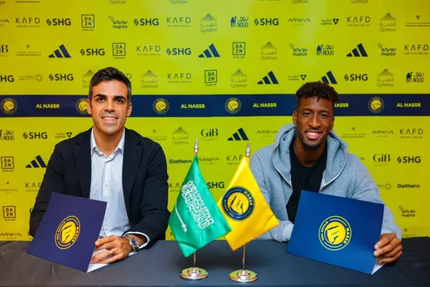 كومان خلال توقيع العقد مع المدير الرياضي سياو كوتينيو (موقع النادي)