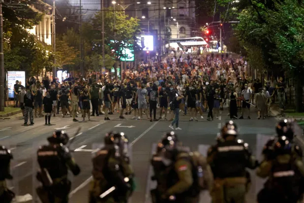 متظاهرون بمواجهة قوة من الشرطة في بلغراد (إ.ب.أ)