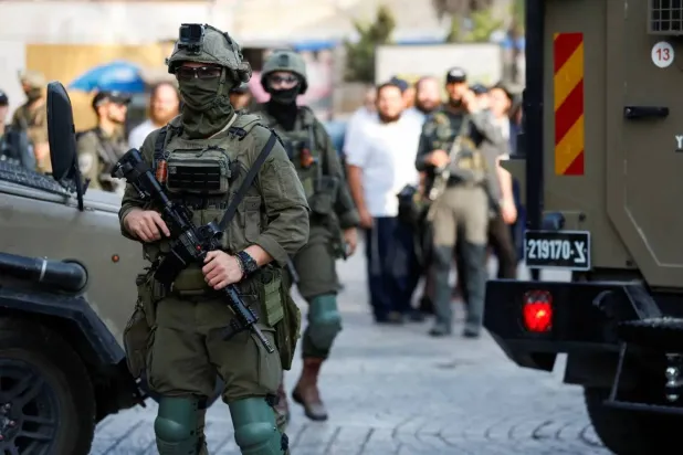 حراسة إسرائيلية أثناء جولة أسبوعية للمستوطنين في الخليل بالضفة الغربية في 9 أغسطس 2025 (رويترز)