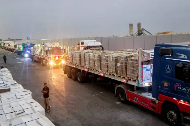 شاحنات تحمل مساعدات إنسانية تصطف بالقرب من معبر رفح الحدودي بين مصر وقطاع غزة (رويترز)