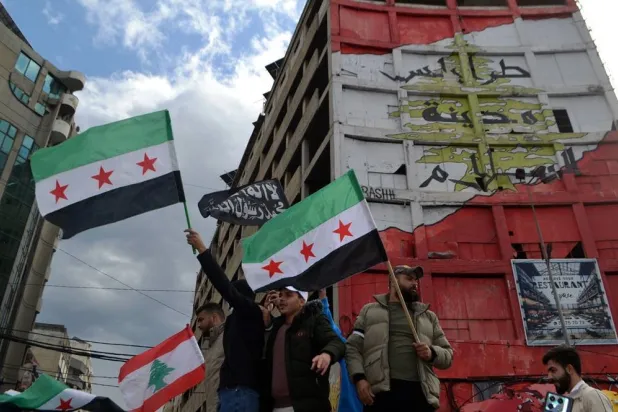 People carry Syrian flags of the opposition as they celebrate the ouster of the Assad regime in Damascus, in Tripoli, northern Lebanon, 08 December 2024. (EPA)
