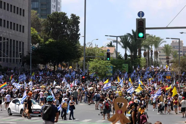 متظاهرون يرفعون أعلاماً خلال احتجاج مناهض للحكومة الإسرائيلية في تل أبيب يوم الأحد (أ.ف.ب)