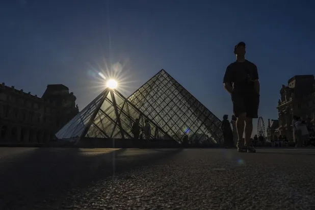 Tourists walk near the Louvre in Paris, Sunday, Aug. 17, 2025. (AP)