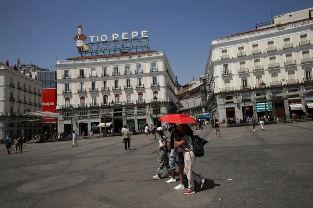 People protect themselves with an umbrella during a heatwave in Madrid, Spain, August 5, 2025. (Reuters)