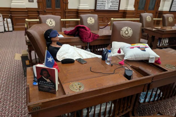 النائبة الديمقراطية في تكساس نيكول كولير نائمة داخل قاعة مجلس النواب في أوستن احتجاجاً على خطط الجمهوريين لإعادة رسم الدوائر الانتخابية بالولاية (رويترز)
